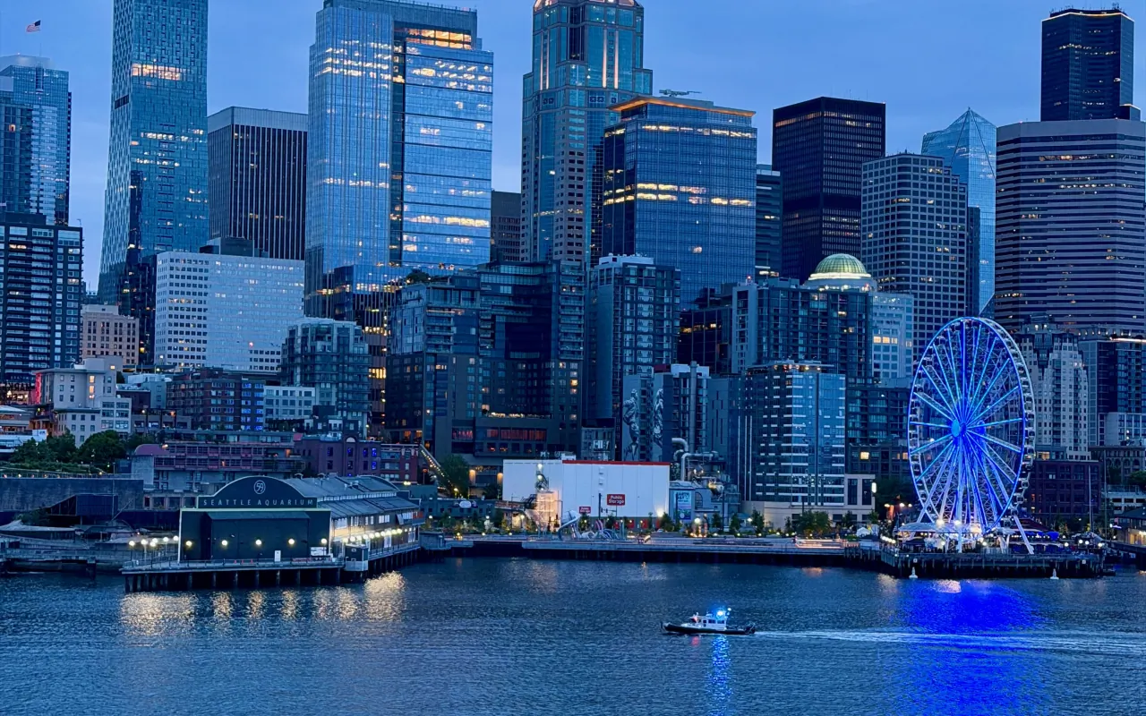 A waterfront city skyline lit at dusk